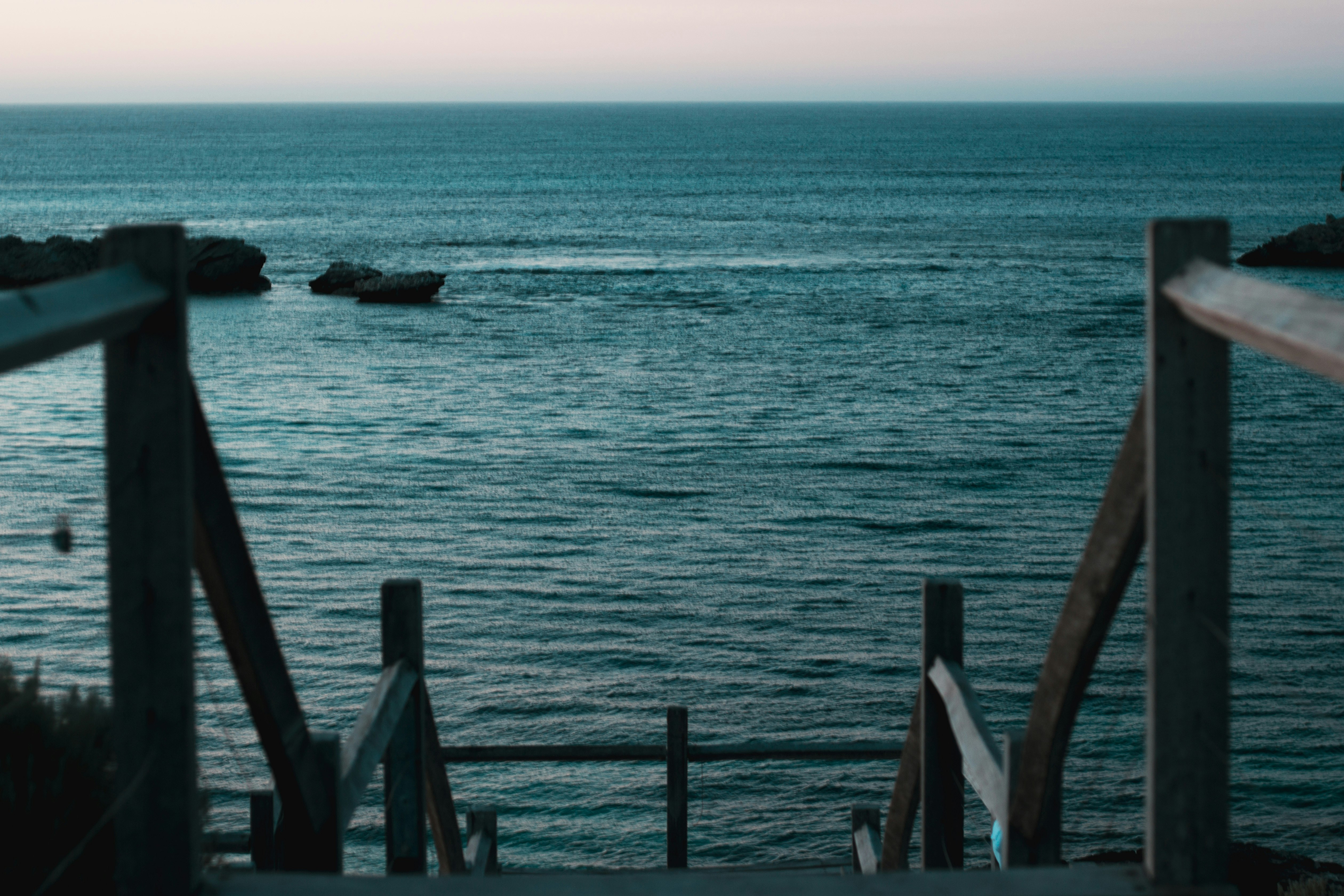 brown wooden dock on blue sea during daytime